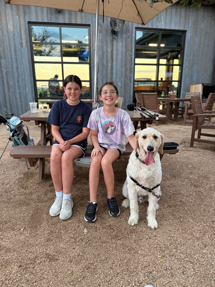 The DoubleTrouble Golf twins and their dog at the course